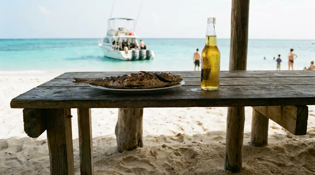 Fresh fish and a cold beer at a beach table