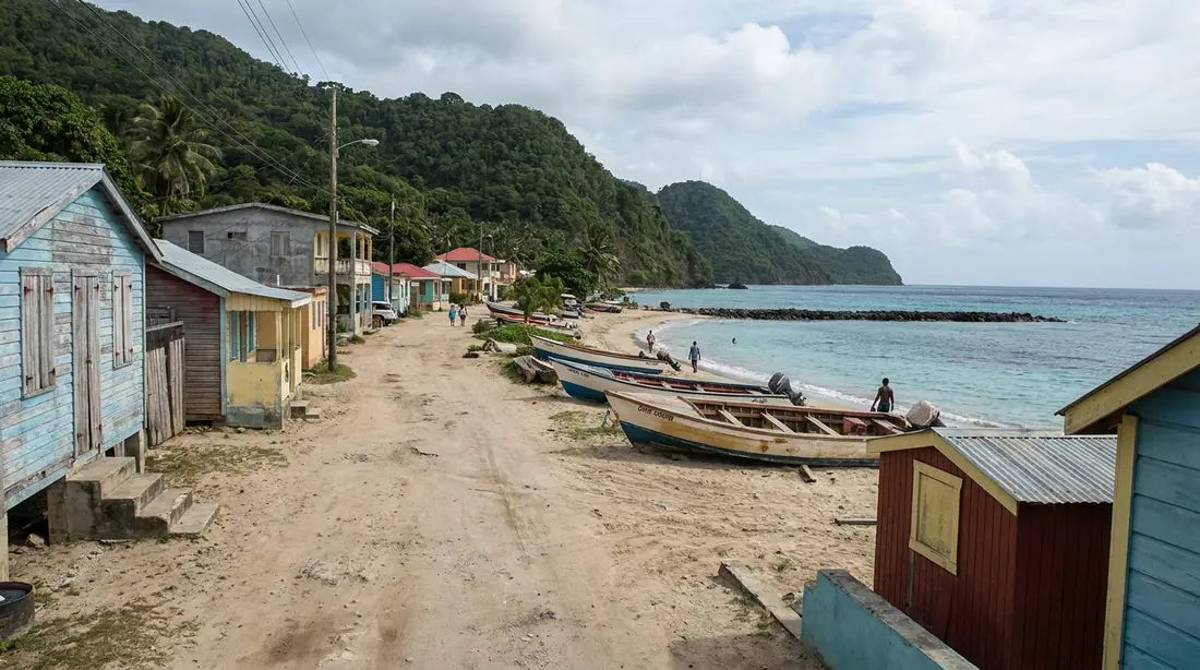 A beach road and dive boats beneath steep green hills