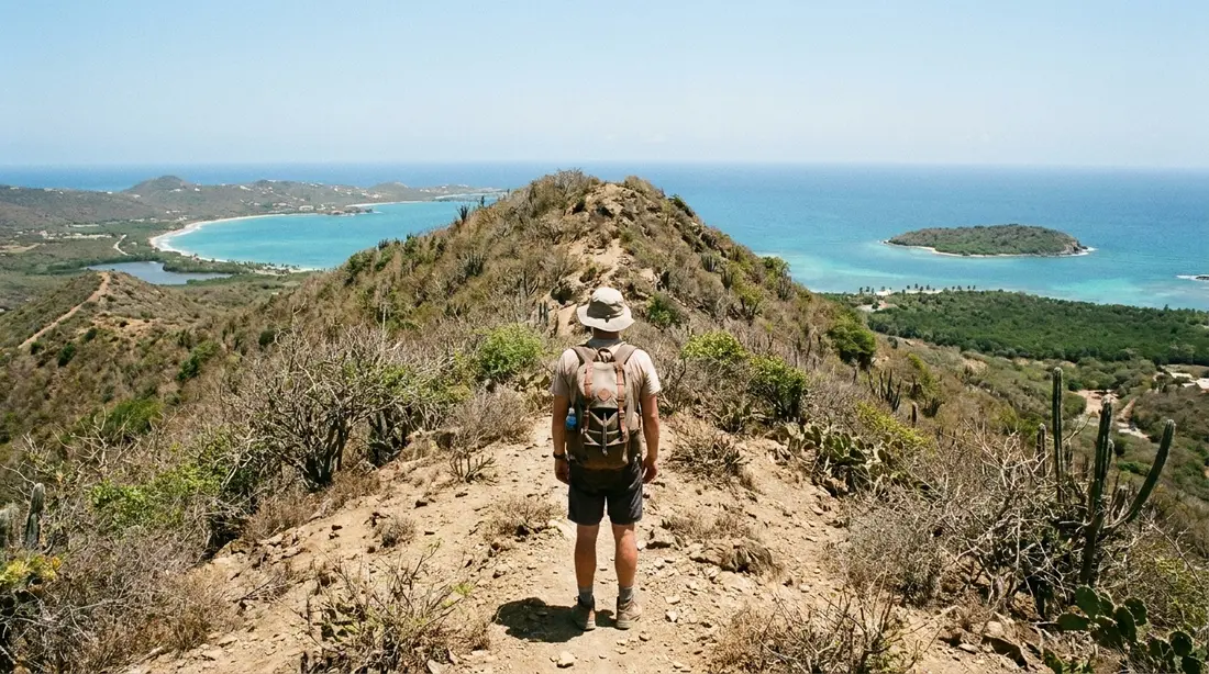 A hiker on a dry summit ridge with both coasts in view