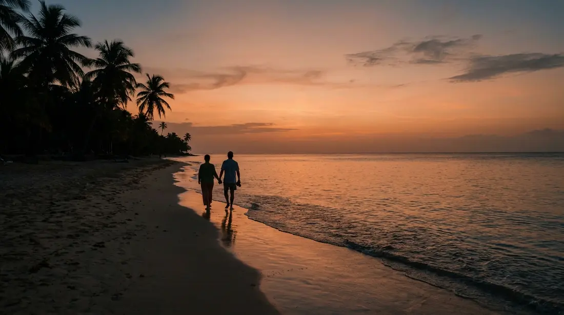 A couple walking an empty beach at sunset