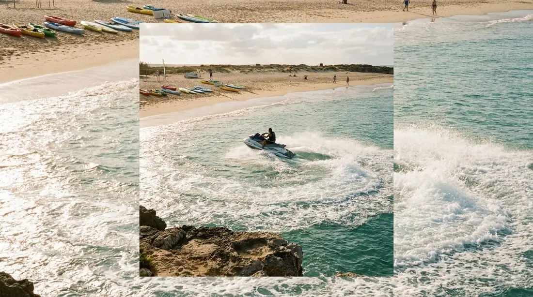 A jet ski turning on calm water near a beach
