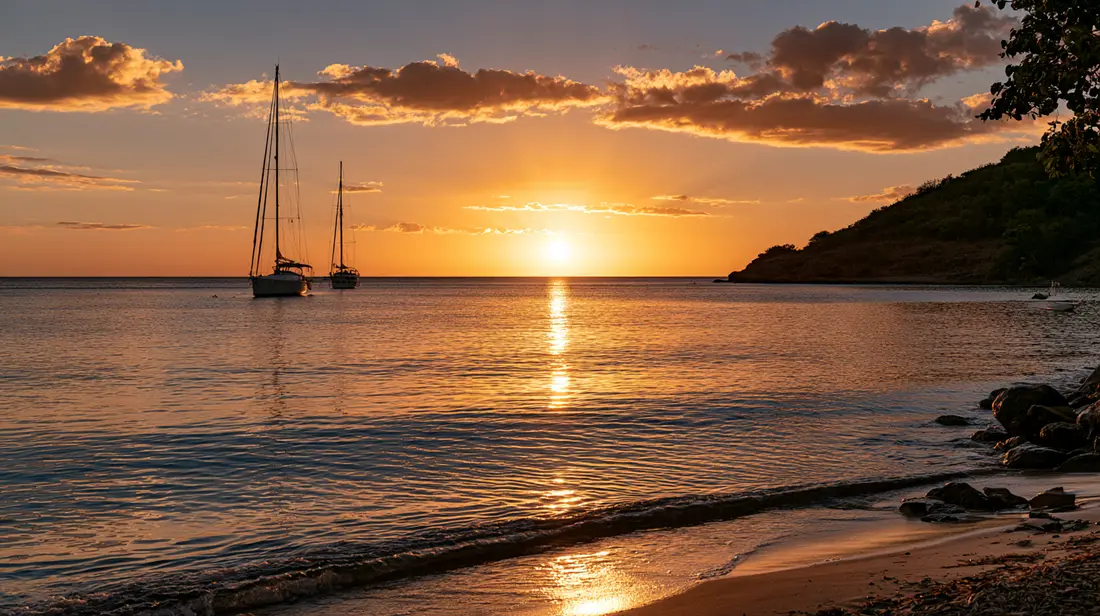 Two sailboats at sunset below a hilly headland