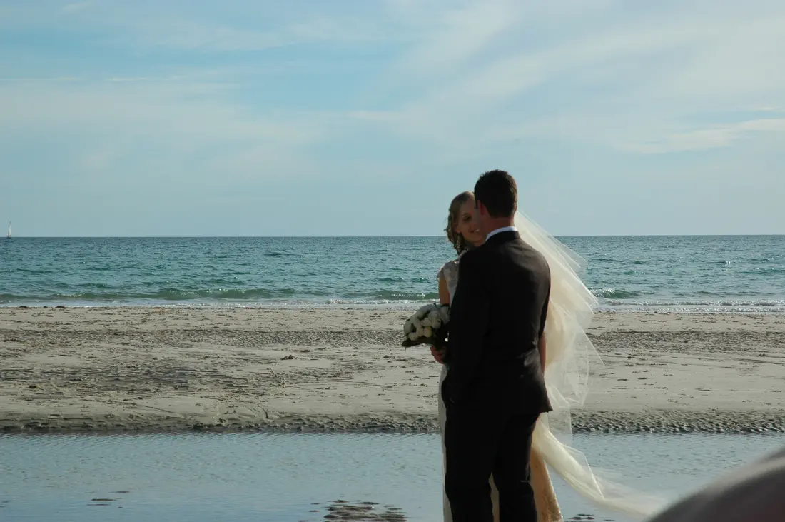 A bride and groom at the shoreline after the ceremony